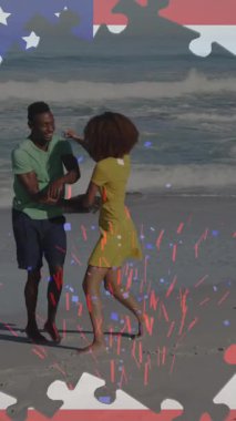 Amerikan bayrağı yapbozlarının animasyonu konfetiyi ortaya çıkarıyor, kumsalda kadın sırtında taşıyan adam. ABD vatanseverliği, kutlama ve demokrasi kavramı dijital olarak oluşturuldu.