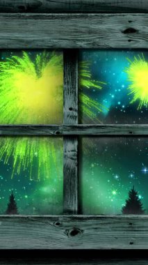 Gökyüzünde yeşil noeller ve yeni yıl havai fişeklerinin patladığı bir pencere animasyonu. Noel, yeni yıl, kutlama, parti ve geleneksel konsept dijital olarak oluşturulmuş video.