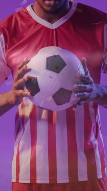 Futbol oynayan Afro-Amerikan futbolcunun üzerine düşen konfeti animasyonu. Spor, rekabet, kazanma ve kutlama konsepti dijital olarak oluşturulmuş video.