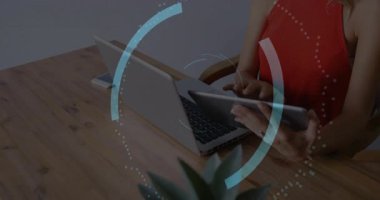 Kadın masadaki tableti tıklatıyor, dizüstü bilgisayarın etrafındaki bulut kilitlerini etkinleştiriyor ve teknoloji bağlantısı kuruyor. Teknoloji, siber güvenlik, yenilik, dijital, arayüz, çalışma alanı, koruma