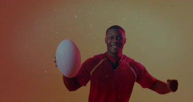 Sporcu kameraya doğru topu itiyor, kollarını esneterek sporu kutluyor sürüklenen parçacıklarla kazanıyor. Dinamik, muzaffer, enerjik, performans, motivasyon, güç, fitness