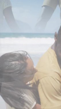 Mutlu Afro-Amerikan çiftlerinin kucaklaşması ve kumsalda yürümesi. sağlık, rahatlama, romantizm ve refah konsepti dijital olarak oluşturulmuş video.