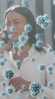 Covid-19 hücreleri, maske takmış, akıllı telefondan konuşan kadınlara karşı yüzüyorlar. Coronavirüs covid 19 salgın konsepti