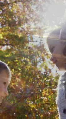 Beyaz bir erkek ve kızın dijital bileşimi. Parkta ağaçlar ve çimenlerle oynuyor.