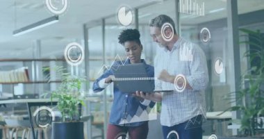 Dizüstü bilgisayarını dinleyen bir kadın ve çalışma arkadaşı çizelgeleri gösterirken aynı zamanda iş değerlendirmesi için gösterge panelini canlandırıyor. İşbirliği, analitik, yenilik, takım çalışması, teknoloji, ticaret, veri