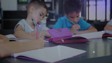 Kamera, sınıf için notlar yazan oğlanlara odaklanıyor, kız ortaya çıkıyor, işe başlamadan önce gülümsüyor. Öğrenciler, eğitim, sınıf, öğrenim, takım çalışması, işbirliği, öğrenim