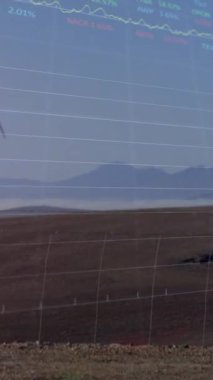 Finansal verilerin animasyonu ve rüzgar türbinleriyle manzara üzerinde grafikler. Ekoloji, yeşil enerji, eko güç, finans ve ekonomi kavramı dijital olarak oluşturulmuş video.