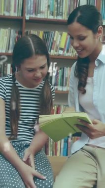 Kütüphanede kitap okuyan bayan öğretmen ve öğrencilere karşı yüzen sayıların ve sembollerin dijital kompozisyonu. okul ve eğitim kavramı