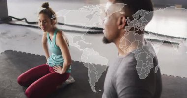 Beden eğitimi stajyeri, kalça menteşesi hareketi için dizlerinin üzerine çöküp dünya haritasını gösteren koçu işaret ediyor. Eğitim, güç, spor, motivasyon, duruş, koçluk, hareket