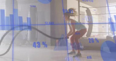 İp yakalayan ve dalga hareketleri yapan bayan sporcu mavi çizelgelerle fitness ölçümlerini takip ediyor. Güç, dayanıklılık, egzersiz, fitness, kararlılık, atletizm, kardiyo