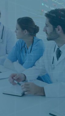 Tıp uzmanları üzerlerinde grafik ve çizelgeler olan verileri tartışıyor. Sağlık, analiz, takım çalışması, teknoloji, istatistik, toplantı