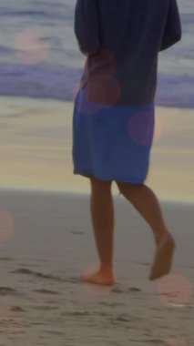 Sahilde yürüyen bir kadının üzerindeki ışık lekelerinin canlandırması. yürüyüş günü ve dijital olarak oluşturulan video konsepti.