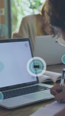 Animation of data processing, 6g icons over caucasian girl writing by laptop at desk. Digital composite, multiple exposure, education, speed, modern, e-learning, internet, technology.