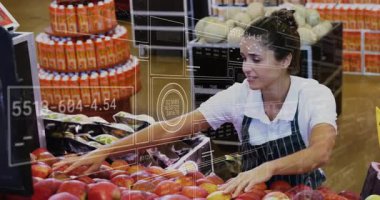 Marketteki tezgahtar kırmızı elmaları sınıflandırıyor dijital grafikleri etkinleştiriyor ve envanteri güncelliyor. Üretim, perakende, taze, dijital, analitik, yönetim, sağlık