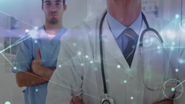 Steteskop takan doktor ve hastane koridorundaki meslektaşı nabzı atıyor, gülümsüyor. Tıbbi, işbirliği, yenilik, sağlık, teknoloji, profesyonellik, modern