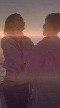 Kumsaldaki beyaz bir çiftin üzerinde ışıklı noktaların canlandırılması. Tatiller ve dijital arayüz kavramı dijital olarak oluşturulmuş video.