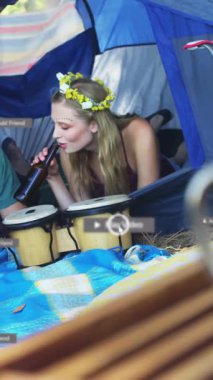 Kamp çadırında müzik çalan arkadaşlarla ilgili sosyal medya bilgilendirmeleri. Açık hava, eğlence, eğlence, seyahat