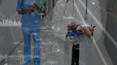 Tıbbi ekip hastane koridorunda yürüyor, dijital ağ sağlık hizmetleri bağlantısını destekliyor. Profesyonel, işbirliği, teknoloji, sağlık, yenilik, hastane, bağlantı