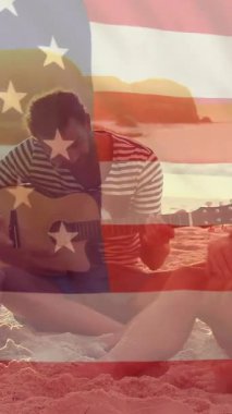 Yazın plajdaki beyaz erkek arkadaşlarının üzerinde ABD bayrağı animajı. Usa, Amerikan vatanseverliği, ulusal bayrak ve yaşam tarzı konsepti dijital olarak oluşturulmuş video.
