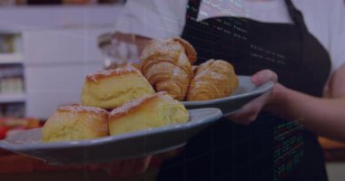 Kafe çalışanı çörekleri ve kruvasanları kaldırıyor, satış eğilimlerini gösteren çizelgeler hazırlıyor. Hamur işleri, kahveci, fırıncı, analitik, ticari, modern, rahat