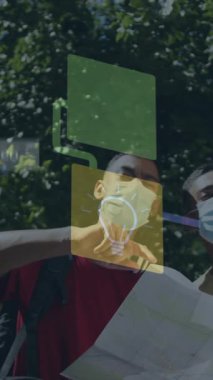 Yüzü maskeli iki erkek arkadaşın sokakta harita okuması üzerine medya simgeleri ağı animasyonu. Dijital olarak üretilen covid 19 pandemik konsept sırasında küresel iletişim ağı ve seyahat.