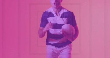 Erkek sporcu, spor eğitimi için pembe-mor stüdyoda rugby topunu manipüle ediyor. Sporcu, antrenman, dinamik, performans, modern, fitness, hareket