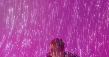 Kadın sanatçı pembe teknolojili ışık tesisatına giriyor ve beyaz topu inceliyor. Fütürist, enerjik, sanatsal, performans, sürükleyici, dinamik, minimalist