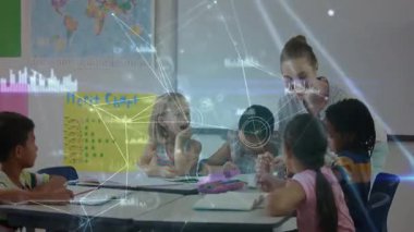 Öğretmen sınıf öğrencilerine yaklaşıyor, ağ kaplamalı defter rehberine işaret ediyor. Sınıf, eğitim, öğrenim, çocuklar, öğretmenlik, dijital, okul