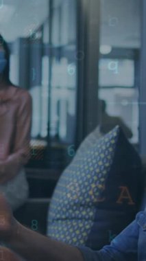 Tablet kullanan yüz maskeli çeşitli iş adamları üzerinde veri işleme animasyonu. Küresel iş bağlantıları ve veri işleme kavramı dijital olarak oluşturulmuş video.