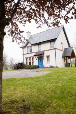 Güneşli bir günde evin dışındaki otlak.