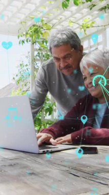 Evde dizüstü bilgisayar kullanarak yaşlı çiftin üzerinde dönen bağlantı ağlarının animasyonu. küresel ağ, bağlantı ve iletişim konsepti dijital olarak oluşturulmuş video.