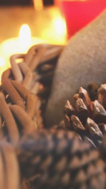 Çam kozalakları ve mumlarla süslenmiş yılbaşı süslemelerinin üzerindeki ışığın bileşimi. Noel, gelenek ve kutlama konsepti dijital olarak oluşturuldu.