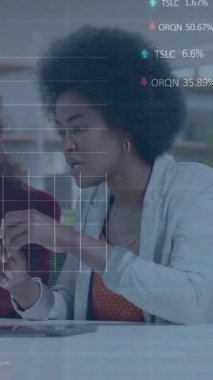 Animation of financial data processing over diverse businesswomen in office. Global business, finance, computing and data processing concept digitally generated video.