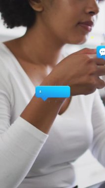 Animation of social media icons over african american women drinking coffee. Social media and communication concept digitally generated video.
