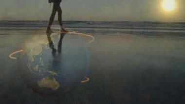 Alçak açılı, ıslak kumda yürüyen, ayakları altında dönen ve gün batımında dans eden bir kadın. Gerçeküstü, yansıtıcı, dinamik, aydınlık, barışçıl, meditasyoncu, atmosferik