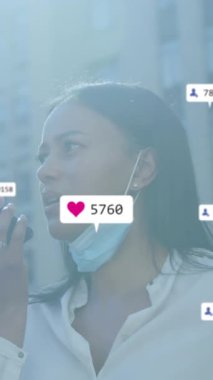 Siyah bir kadın akıllı telefonuyla konuşuyor ve şehir caddesinde yürürken maske takıyor. Dijital arayüz teknolojisi ve bağlantılar konsepti dijital olarak oluşturuldu.