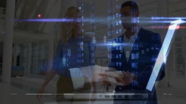 Kadın ve erkek atriyuma giriyor, dizüstü bilgisayarda açıp yazarak finansal grafikleri canlandırıyor. İş, finans, analiz, veri, teknoloji, işbirliği, kurumsal