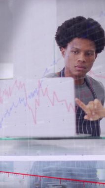 Animation of numbers and data processing over diverse couple using laptop in shop. Global shopping, business, finance, computing and data processing concept digitally generated video.