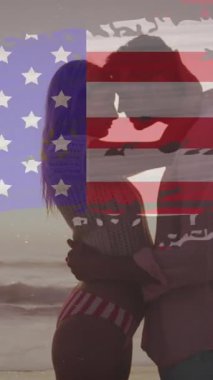 Sahilde birbirini kucaklayan çifte karşı kusurlu Amerikan bayrağı. Amerika 'nın bağımsızlığı vatansever tatil konsepti