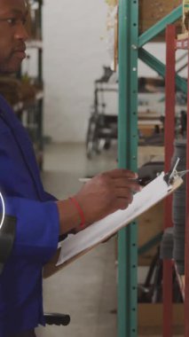 Afro-Amerikan bir adamın depoda çalışması üzerine simge ağının animasyonu. Küresel sevkiyat, iş, finans, bilgisayar ve veri işleme kavramı dijital olarak oluşturuldu.