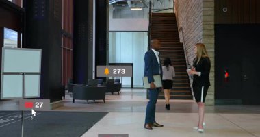 Takım elbiseli bir adamın yanındaki akıllı telefonu dinleyen kadın şirket lobisinde medya ikonlarının yükselmesine yol açıyor. Profesyonel, ağ, iletişim, teknoloji, modern, kurumsal, dijital