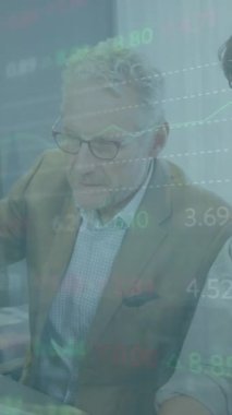 Animation of financial data processing over diverse business people using computer in office. Global business, finance, computing and data processing concept digitally generated video.