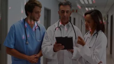 Kıdemli doktor tıkırtı tableti, sağlık ekibinin incelediği animasyon çizelgesini gösteriyor. Tıbbi, takım çalışması, işbirliği, profesyoneller, klinik, tanı, iletişim