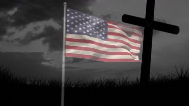 Hafif bir esinti başlıyor bayrak dalgalanıyor ve haçın yanında dalgalanıyor çimlerin üzerinde anıt olarak duruyor. Vatanseverlik, anma, sembolizm, kasvetli, doğa, ciddiyet, esneklik