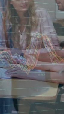 Ofiste dizüstü bilgisayarla çalışan mutlu iş adamlarının grafiklerinin animasyonu. işletme, işbirliği, ekonomi ve teknoloji konsepti dijital olarak oluşturulmuş video.