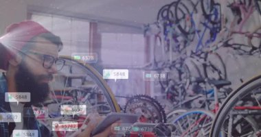 Tamirci bisiklet atölyesindeki tableti inceliyor, kayan ölçümlerle direksiyonu test etmek için çizelgeleri kaydırıyor. Teknisyen, elektronik, şehir, yenilik, teknoloji, üretkenlik, modern