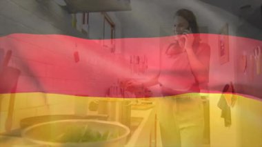 Animasyon ikonlar sağlıklı yemek hazırlıklarına rehberlik ederken mutfakta çalan telefona hamile bir kadın bakıyor. Hamilelik, aile içi, yaşam tarzı, aşçılık, sağlık, hazırlık, ev yapımı.