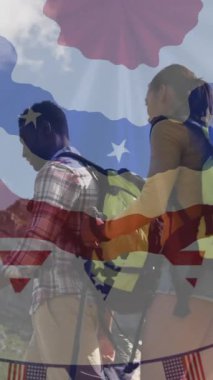 Dağlarda yürüyüş yapan gülümseyen çift üzerine Amerikan bayrağı animasyonu. Vatanseverlik ve kutlama konsepti dijital olarak oluşturulmuş video.