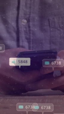 Animation of social media icons with numbers over caucasian man using smartphone. Global social media, technology and digital interface concept digitally generated video.