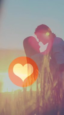 Günbatımında birbirini öpen çiftlerin orta kısmında yüzen kırmızı kalp simgelerinin animasyonu. Dijital ortamda oluşturulan Sevgililer Günü kutlaması konseptiniz kutlu olsun..